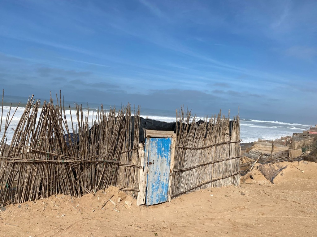 Traditional fisherman reed hut with a blue door at Aglou plage